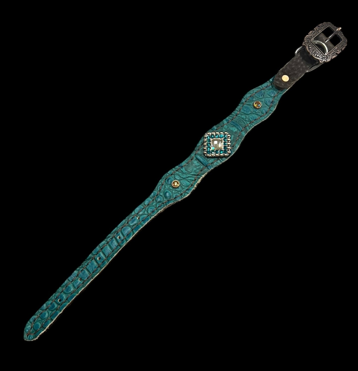Teal gator on dark leather