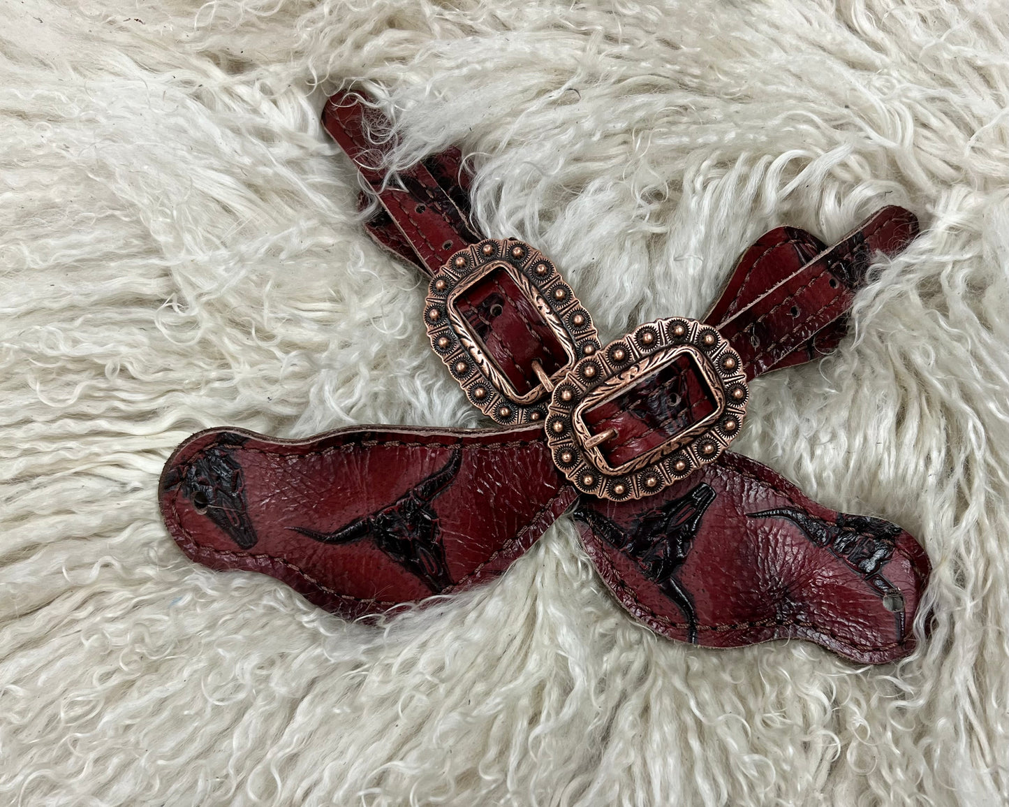 Red longhorns on dark leather